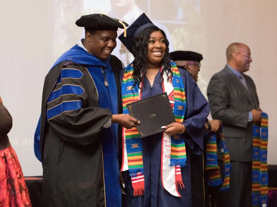 Africana Studies Department Head Praise Zenenga celebrates with a new graduate at convocation. 