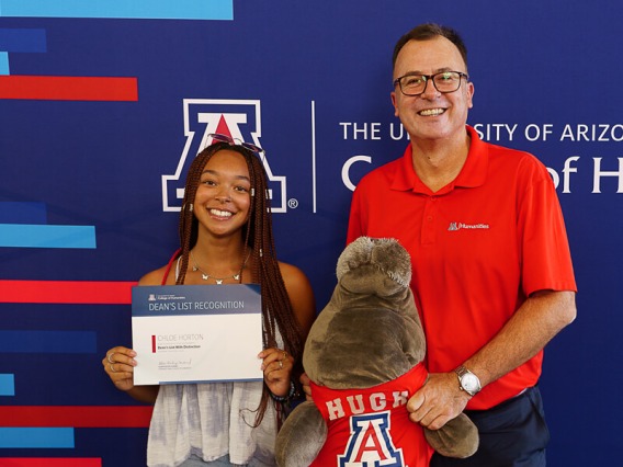 Student standing next to Dean and holding award certificate